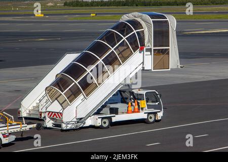 Scale mobili per l'imbarco e l'imbarco dei passeggeri parcheggiati in aeroporto Foto Stock