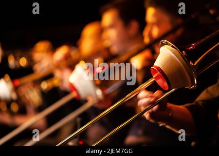 Big Band: Sezione trombone. Astratto fuoco superficiale sulle diapositive di una sezione di trombone muto. Da una serie di immagini di musicisti in una band swing Jazz. Foto Stock