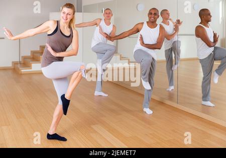 Persone adulte che addestrano i movimenti di danza in classe di coreografia Foto Stock