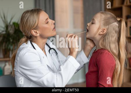 Angina, tonsillite, raffreddore e influenza nei bambini concetto. Medico pediatra femmina controllo paziente gola ragazza piccola Foto Stock