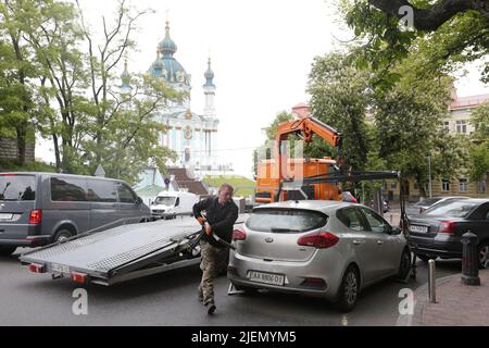La squadra di camion di traino si prepara a rimuovere l'auto parcheggiata illegalmente dalla strada vicino alla leggendaria chiesa di St Andrews a Kiev, sulla cima di St Andrew Hill Foto Stock