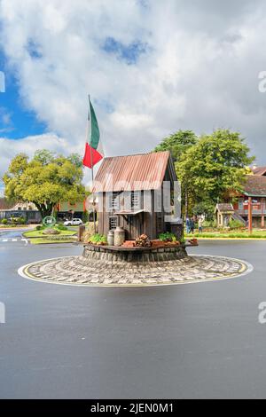 Gramado, RS, Brasile - 17 maggio 2022: Mini casa tematica con bandiera italiana nel mezzo della rotonda di fronte a piazza Praca das Etnias. Foto Stock