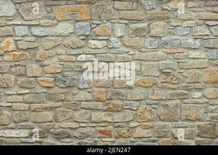 Robusto muro in pietra tagliato di giallo e beige, adatto per sfondi Foto Stock