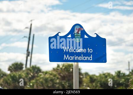 Marineland, USA - 19 ottobre 2021: Benvenuti a Marineland segno blu nel nord della Florida Palm Coast con River to Sea Preserve Beach in giorno di sole Foto Stock