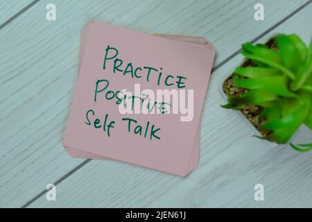 Concetto di pratica positiva Self Talk scrivere su note appiccicose isolato su tavola di legno. Foto Stock
