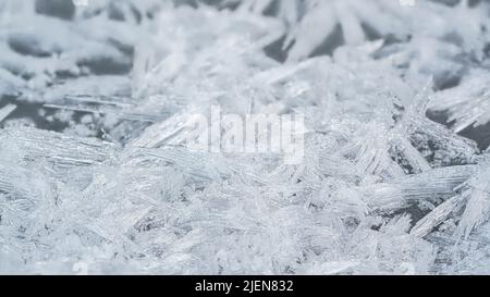 Ghiaccio e cristalli di neve che formano forme di punta sul fiume congelato, primo piano macro dettaglio, astratto sfondo invernale Foto Stock
