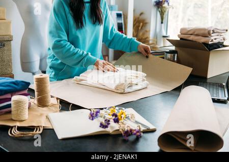 Piccola impresa proprietario donna imballare la merce in eco imballaggio in ufficio, negozio. Foto Stock