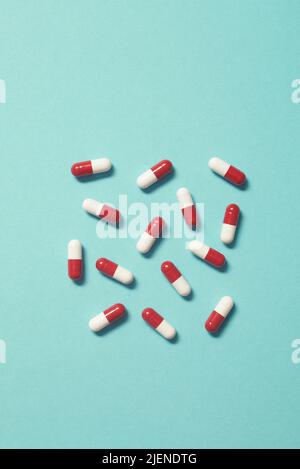 Pillole farmaceutiche su sfondo turchese. Foto Stock