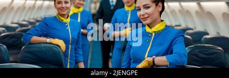 Lavoratori aerei che si trovano in cabina passeggeri dell'aeroplano Foto Stock