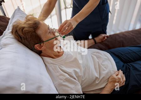 Medico che mette una maschera respiratoria su una paziente con covid-19 Foto Stock