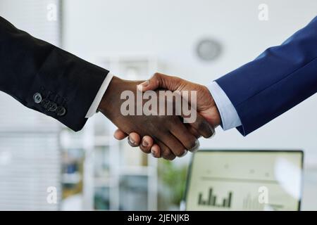 Primo piano di due persone che agitano le mani dopo aver negoziato con successo la partnership in ufficio Foto Stock