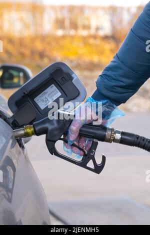 Prezzo del carburante in Europa. Rifornimento della pistola car.Refilling nelle mani di un man.Car ad una stazione di benzina. Auto, rifornimento di pistole e guanti.man riempie un Foto Stock