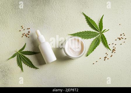 Olio di canapa di cannabis, foglie e prodotti di bellezza, olio cbd in bottiglia, creme e siero per il viso, medicina alternativa e concetto di cura biologica della pelle. Foto Stock