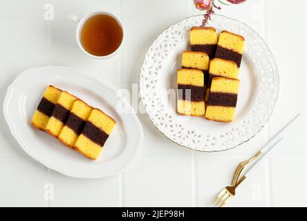 Top View Mini Spiku Lapis Surabaya, torta a tre strati originata da Surabaya, Indonesia. Servito con tè Foto Stock