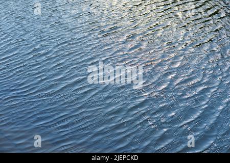 Calma ondulazione sulla superficie dell'acqua. Fiume, lago, stagno, mare acqua pura blu. Foto Stock