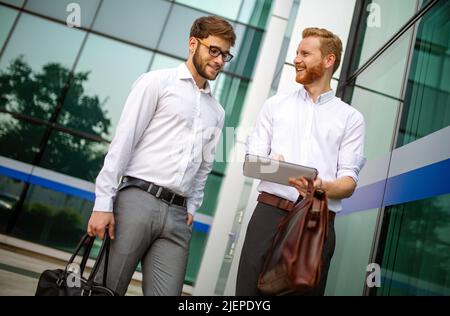 Due uomini d'affari di successo che camminano all'aperto. Business, amicizia, comunicazione concetto Foto Stock