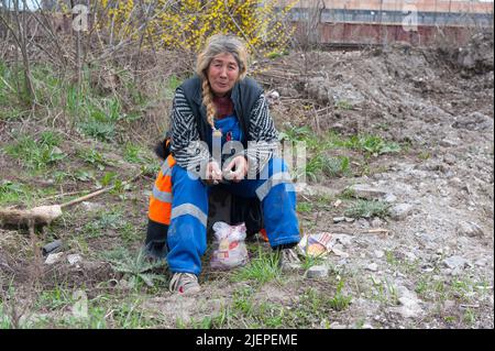 Sofia, Bulgaria. Ritratto di una donna matura, adulta, caucasica seduta, riposante e rilassante lato strada sul teso di una linea ferroviaria, prima di passeggiare ulteriormente nella zona del centro. Foto Stock