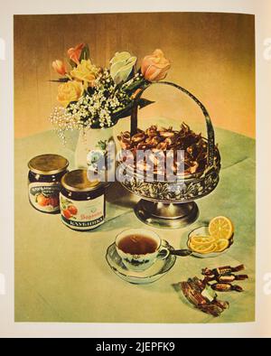 Un'esposizione di vari prodotti da dessert, tra cui caramelle dure, avvolte, gelatina di frutta, marmellata e tè caldo. Dalla classica edizione 1955 del Soviet, Russo Foto Stock