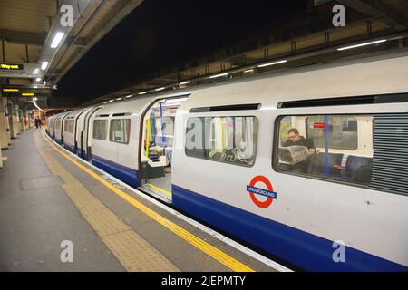 Londra, Regno Unito. Appena arriva il treno della metropolitana in attesa di partenza dalla stazione della metropolitana di Acton Town per trasportare pendolari in tarda notte in tutta la capitale britannica. Foto Stock