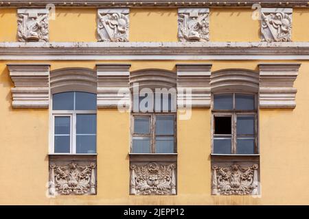 Le finestre del vecchio edificio sono decorate con stucchi in stile sovietico. Foto Stock