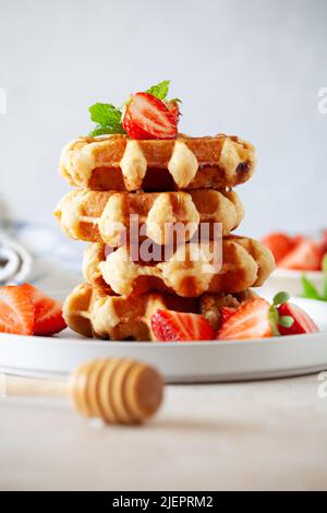 Impila di waffle fatti in casa con fragole biologiche e miele Foto Stock