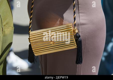 MILANO, ITALIA - 19 GIUGNO 2022: Donna con borsa metallica Yves Saint Laurent dorata prima della sfilata di moda Etro, Street style Milano Fashion Week Foto Stock