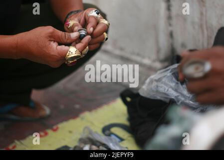 Primo piano dell'anello dell'agata di raccolta a mano del cliente nel mercato di strada di Yogyakata, Java, Indonesia Foto Stock