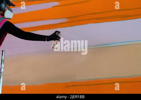 Magdeburg, Germania. 28th giugno 2022. L'artista Claudia Walde spruzza il suo graffito sulla parete di cemento del deposito del ponte in un cavalcavia ferroviario alla stazione principale. È uno dei due graffiti di 250 metri quadrati ciascuno dall'artista, che decorerà il re-immagazzinaggio in avvenire. Il lavoro dovrebbe essere terminato entro la fine della settimana. Vernice da circa 300 lattine allora sarà spruzzata sul calcestruzzo. Credit: Klaus-Dietmar Gabbert/dpa/Alamy Live News Foto Stock