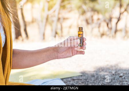 donna che prova gli oli aromatherpy su un rituale di consapevolezza di estate. concetto sano di vita. solstizio di estate. Foto Stock