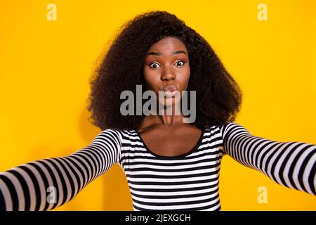 Foto ritratto di donna curly presa selfie invio aria bacio isolato vivido giallo sfondo di colore Foto Stock