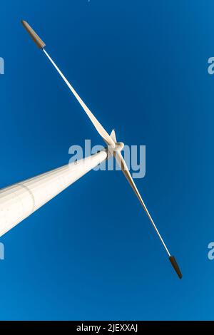 Vista verticale delle pale di una turbina eolica con cielo blu sullo sfondo. Concetto di energia rinnovabile. Foto Stock