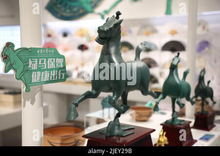 LANZHOU, 28 giugno 2022 (Xinhua) -- i souvenir che presentano un'antica statua del cavallo di bronzo sono visti in un negozio nel Museo Provinciale di Gansu a Lanzhou, capitale della provincia di Gansu della Cina nord-occidentale, 28 giugno 2022. La statua del cavallo di bronzo, popolarmente conosciuta come 'Bronze Galloping Horse Treading on a Flying Swallow', fu messa alla luce nel 1960s dalla Tomba Leitai della Dinastia Eastern Han (25-220 d.C.) a Wuwei ed è ora conservata nel Museo Provinciale di Gansu. (Xinhua/ma Xiping) Foto Stock