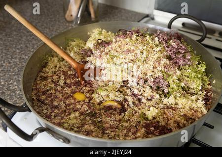 Masse di fiori a fiore casuale di anziano utilizzati in biologico casa estate bere cordiale simmering in alluminio marmellata padella Foto Stock