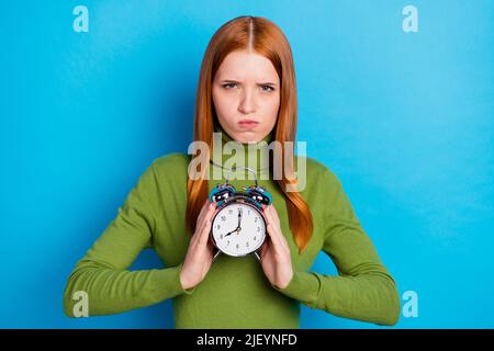 Ritratto di attraente moody ragazza tenuta in palme orologio mattina presto isolato su sfondo di colore blu chiaro Foto Stock