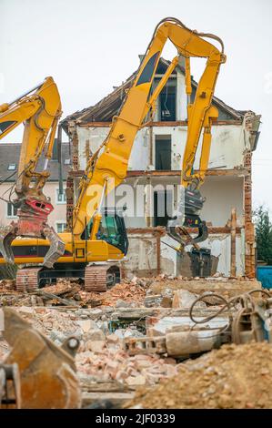 Escavatore per impieghi gravosi che demolisce un vecchio edificio residenziale Foto Stock