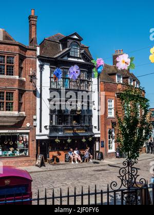 Guildford High Street & Public house con banner colorati, telefono tradizionale rosso e storico tre pidoggeons pubblica casa Guildford Surrey Foto Stock