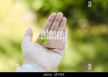 Mano che tiene carta bianca scheda isolata su sfondo naturale. Estate, concetto di Ecologia. Spazio copia, simulazione Foto Stock