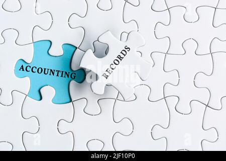 Contabilità registra il testo su sfondo blu di puzzle bianco. Foto Stock