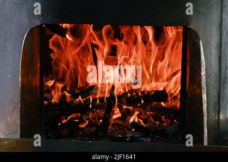 Fuoco fiamme da una stufa a legna fuoco isolato su uno sfondo nero Foto Stock