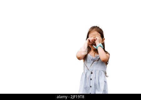 Adorabile ragazza sconvolto bambino piangendo su sfondo bianco. Il bambino piangente chiude il viso con le mani. Problemi del bambino Foto Stock