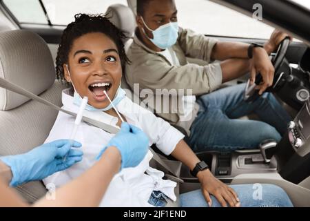 Black Woman Getting testato per Covid-19 seduta in Auto Foto Stock