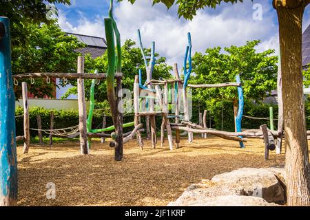 Parco giochi pubblico vuoto nelle giornate di sole con attrezzature da gioco in legno Foto Stock