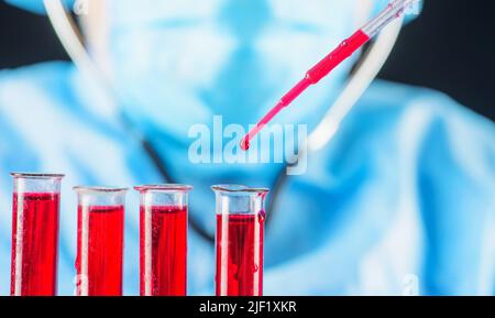 Ricerca di laboratorio. Operatore medico, medico o scienziato che gocciola il sangue nelle provette. Foto Stock