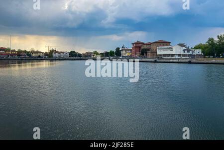 Ravenna, Italia: 10-04-2022: Splendidi edifici riflessi sulla darsena di Ravenna in una giornata di sole mattutina. Un molo è un'area coperta d'acqua per la quale viene utilizzata Foto Stock