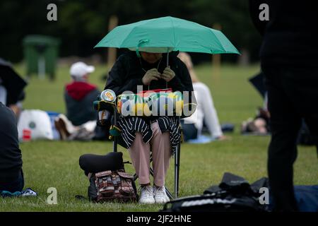 Una persona in coda ospita sotto un ombrello davanti al terzo giorno dei campionati di Wimbledon 2022 all'All England Lawn Tennis and Croquet Club, Wimbledon. Data foto: Mercoledì 29 giugno 2022. Foto Stock