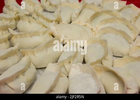 Gnocchi cinesi crudi, non cotti in casa su un piatto d'argento Foto Stock