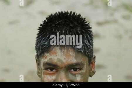 Kathmandu, Nepal. 29th giugno 2022. Un ragazzo con fango sul suo viso è raffigurato mentre celebra il giorno Nazionale Paddy, chiamato anche Asar Pandra festival, che segna l'inizio di colture di riso piantando in risaie, a Kathmandu, Nepal 29 giugno 2022. (Credit Image: © Dipen Shrestha/ZUMA Press Wire) Foto Stock