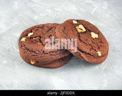 Tre biscotti al cioccolato su sfondo chiaro Foto Stock