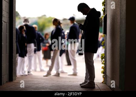 I giudici della linea aspettano fuori dal campo centrale durante il terzo giorno dei campionati di Wimbledon 2022 all'All England Lawn Tennis and Croquet Club, Wimbledon. Data foto: Mercoledì 29 giugno 2022. Foto Stock