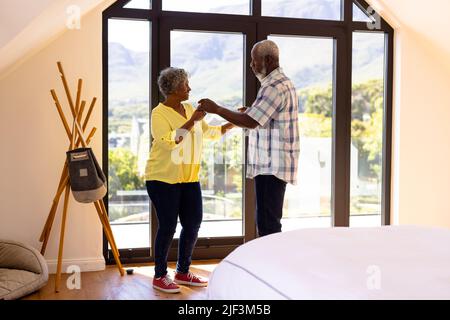 Gli amici anziani afroamericani che fanno la salsa ballare dalla finestra nella casa di cura Foto Stock